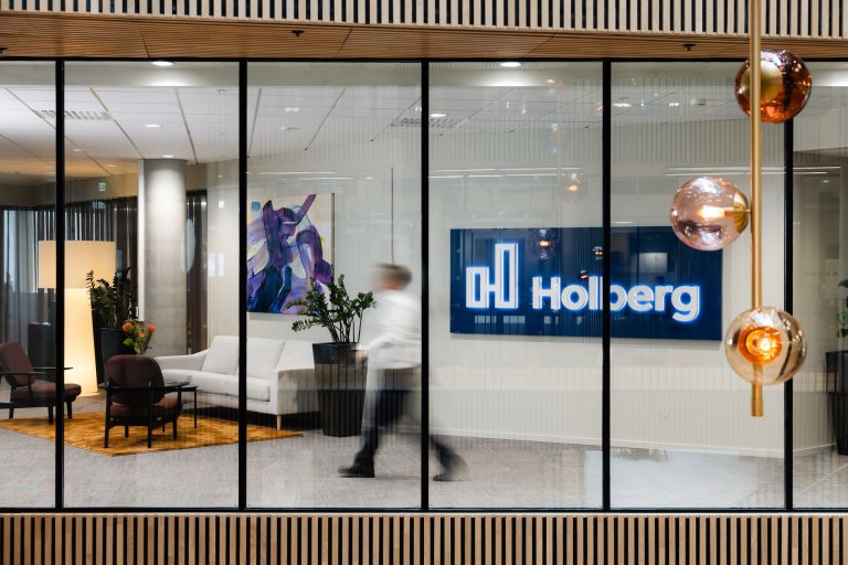 Bilde av en mann som går igjennom Holberg Fondsforvaltnings kontorlokaler