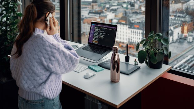 Bilde av en dame som snakker i telefonen ved arbeidsplassen sin