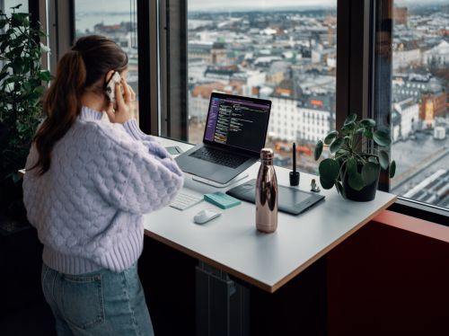 Bilde av en dame som snakker i telefonen ved arbeidsplassen sin