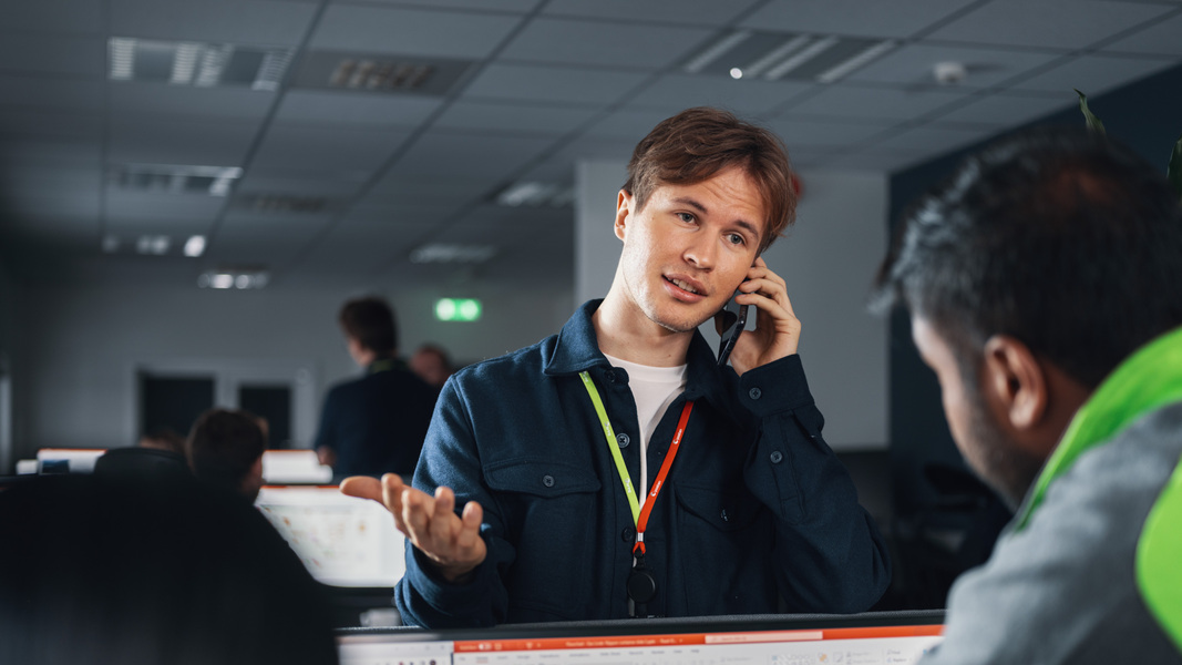 Foto av en Posten ansatt som er i telefonen